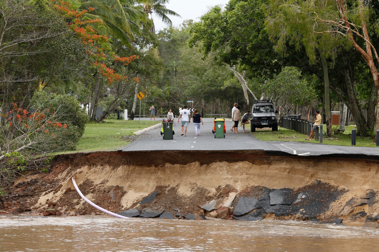 Residents are cut off after a large section of road has washed away at the end of Holloways Beach Esplanade in the suburb of Holloways Beach in Cairns, Monday, December 18, 2023. Residents in far north Queensland are bracing for more rain and further significant flooding. (AAP Image/Joshua Prieto) NO ARCHIVING