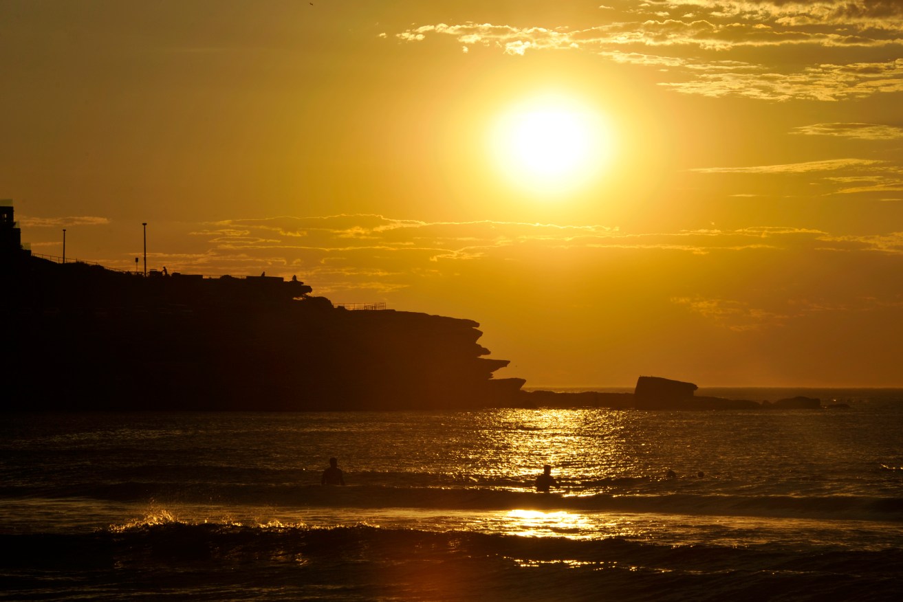 People enjoy the water at sunrise at Bondi Beach in Sydney, Wednesday, Jan. 18, 2017. Temperatures only dropped to the low-20s overnight and the weather is set to warm up to 35C in the city and 42C in the west today. (AAP Image/Joel Carrett) NO ARCHIVING