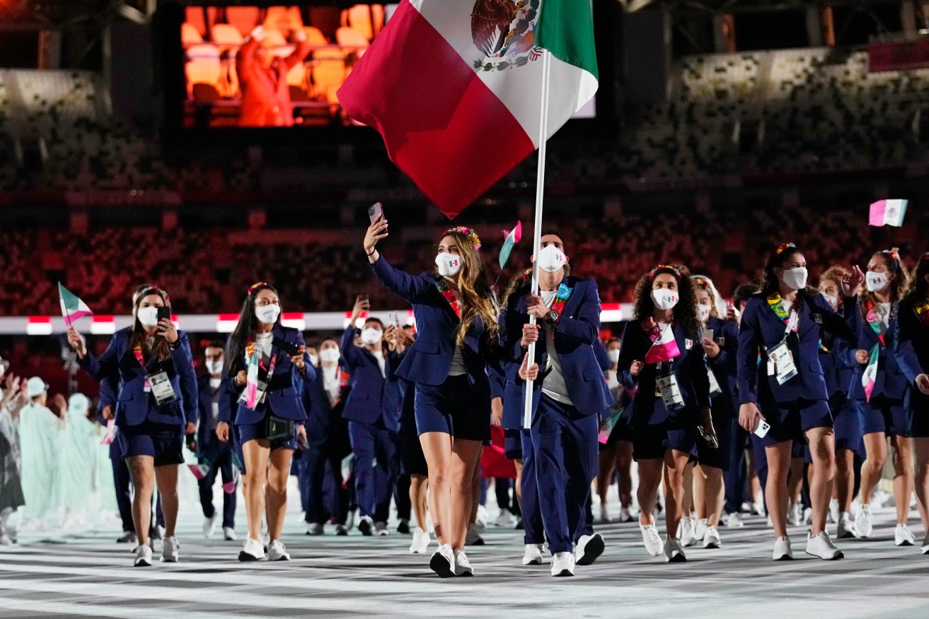 Gaby Lopez and Rommel Pacheco Marrufo, of Mexico, carry their country's flag during the opening ceremony in the Olympic Stadium at the 2020 Summer Olympics, Friday, July 23, 2021, in Tokyo, Japan. (AP Photo/Petr David Josek)