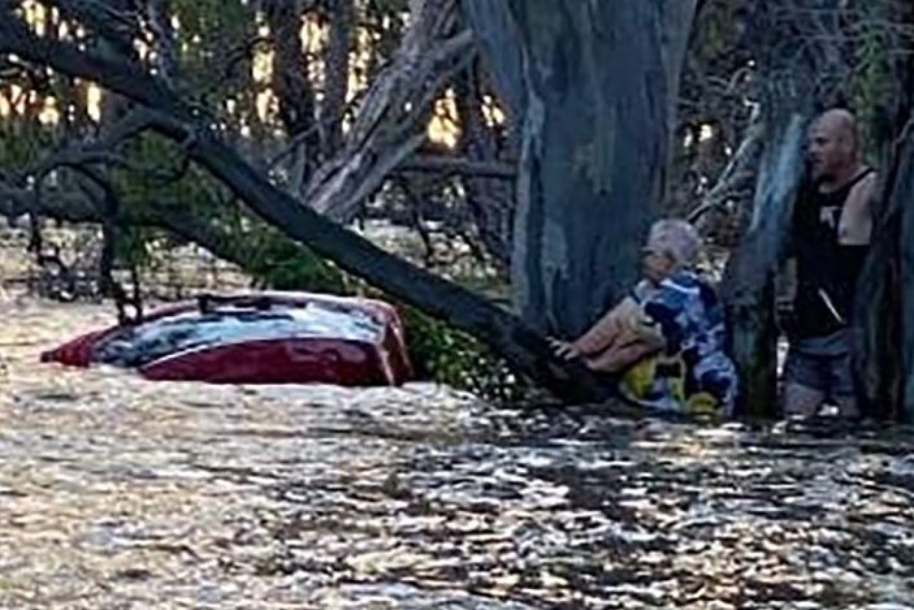 A woman being rescued in flood waters.A woman aged in her 70s is lucky to be alive after she was swept away in flood waters in Elmore last night.. (AAP Image/Victoria Police) 