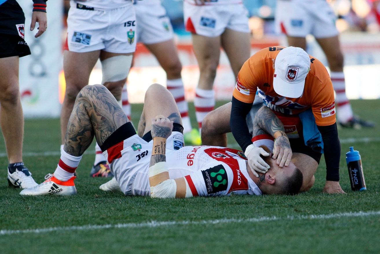 Josh Dugan of the Dragons is checked for a head injury during the Round 16 NRL match between the Newcastle Knights and the St George-Illawarra Dragons at Hunter Stadium in Newcastle, Saturday, June 25, 2016. (AAP Image/Darren Pateman) NO ARCHIVING, EDITORIAL USE ONLY