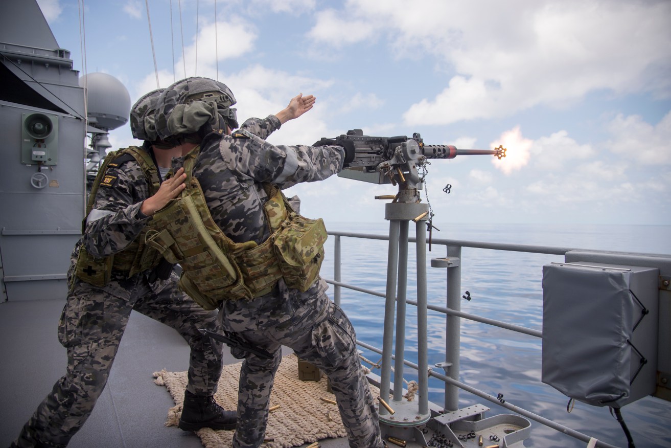 Sailors aboard the HMAS Swan fire a 50-calibre machine gun at fighter jet aircraft on Friday during mock sea battles for the Royal Australian Navy's Exercise Kakadu off the coast of the Northern Territory, Friday, September 23, 2022. (AAP Image/Aaron Bunch) NO ARCHIVING