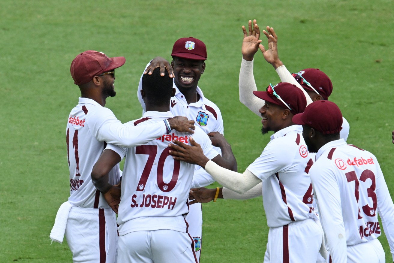 Man of the hour Shamar Joseph (centre) of the West Indies celebrates with team mates after getting the wicket of Travis Head of Australia on Day 4 of the Second Test between Australia and the West Indies at the Gabba in Brisbane, Sunday, January 28, 2024. (AAP Image/Darren England) NO 