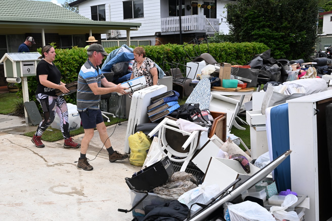 Residents of Federation Drive in the suburb of Bray Park are seen cleaning up their flood damaged properties in Brisbane, Wednesday, January 31, 2024. Heavy rain has lashed an already soaked southeast Queensland, as ex-tropical cyclone Kirrily delivers more wet weather in the state's northwest.  (AAP Image/Darren England) NO ARCHIVING