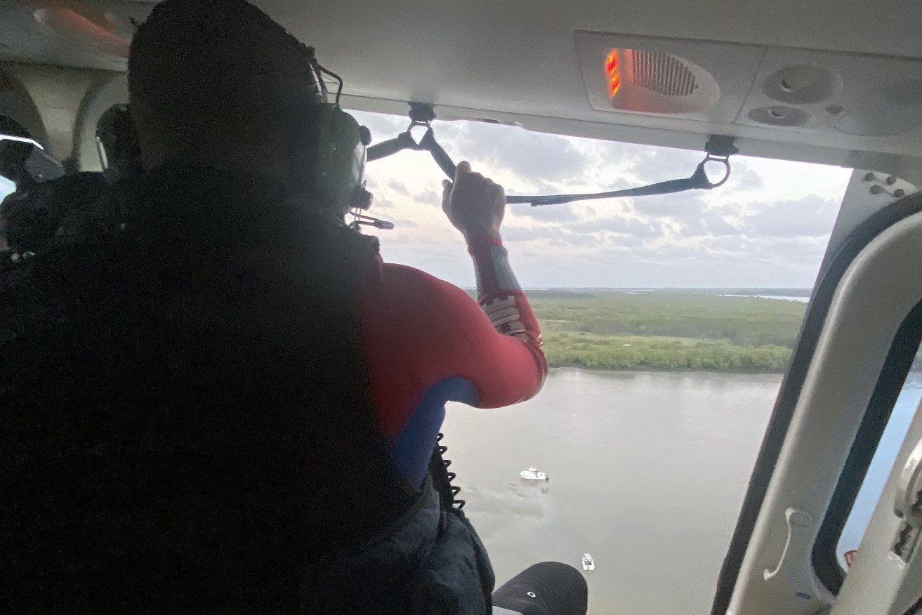 A supplied image obtained on Tuesday, February 27, 2024, shows Emergency services rescuing a man stuck in the mud after falling out of a boat at South Moreton Island. A man in his 60s became stuck in mud before paramedics and helicopter crews rescued him. (AAP Image/Supplied by Queensland Ambulance Service)