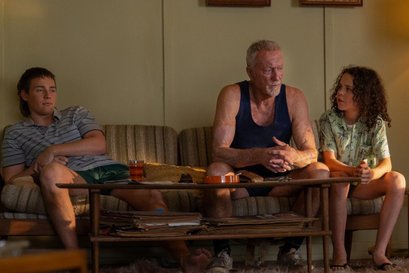 Actors Lee Halley, Bryan Brown and Felix Cameron in a scene from Netflix smash hit Boy Swallows Universe, the latest screen adaptation of a book set in Brisbane. Photo: Courtesy of Netflix © 2023