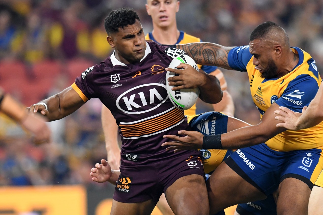 Tevita Pangai Junior (left)  of the Broncos is tackled by Junior Paulo (right) of the Eels during the Round 1 NRL match between the Brisbane Broncos and the Parramatta Eels at Suncorp Stadium. (AAP Image/Darren England) 