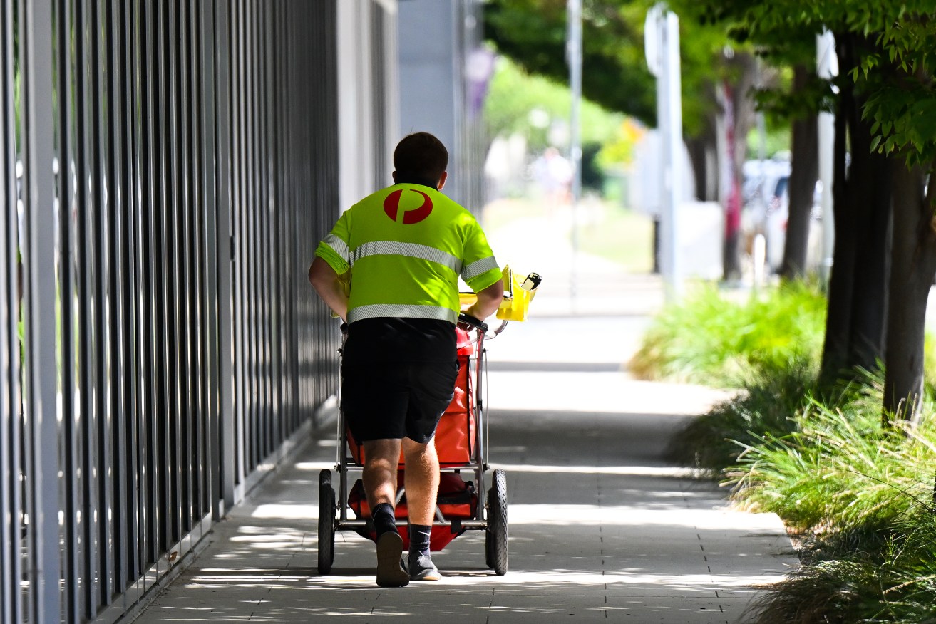 Mail is delivered by an Australia Post employee in Canberra, Thursday, March 2, 2023. (AAP Image/Lukas Coch) NO ARCHIVING