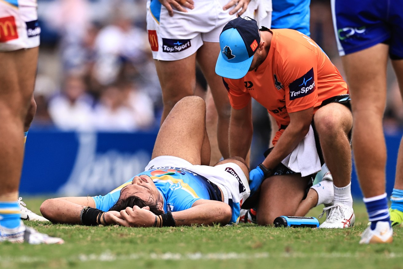 Tino Fa’asuamaleaui of the Titans suffers an injury during the NRL Round 3 match between the Canterbury-Bankstown Bulldogs and the Gold Coast Titans at Belmore Sports Ground in Sydney, Saturday, March 23, 2024. (AAP Image/Mark Evans) 