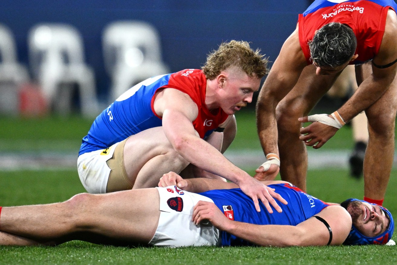 Angus Brayshaw of Melbourne lies on the field after sustaining an injury during the first qualifying final between the Collingwood Magpies and the Melbourne Demons at the MCG. (AAP Image/Joel Carrett) 