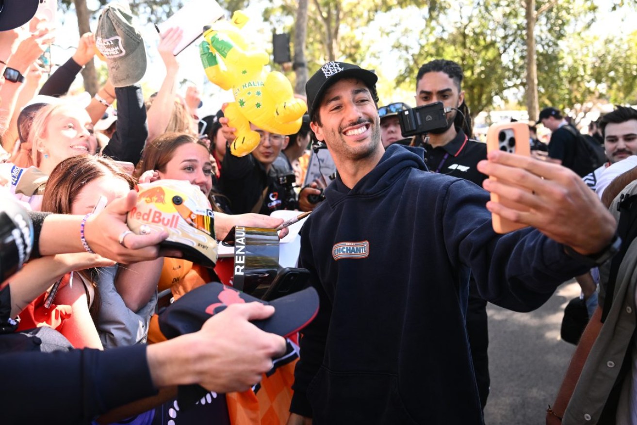 Daniel Ricciardo of RB greets fans on arrival at the Albert Park Grand Prix Circuit in Melbourne, Thursday, March 21, 2024. (AAP Image/Joel Carrett) NO ARCHIVING, EDITORIAL USE ONLY