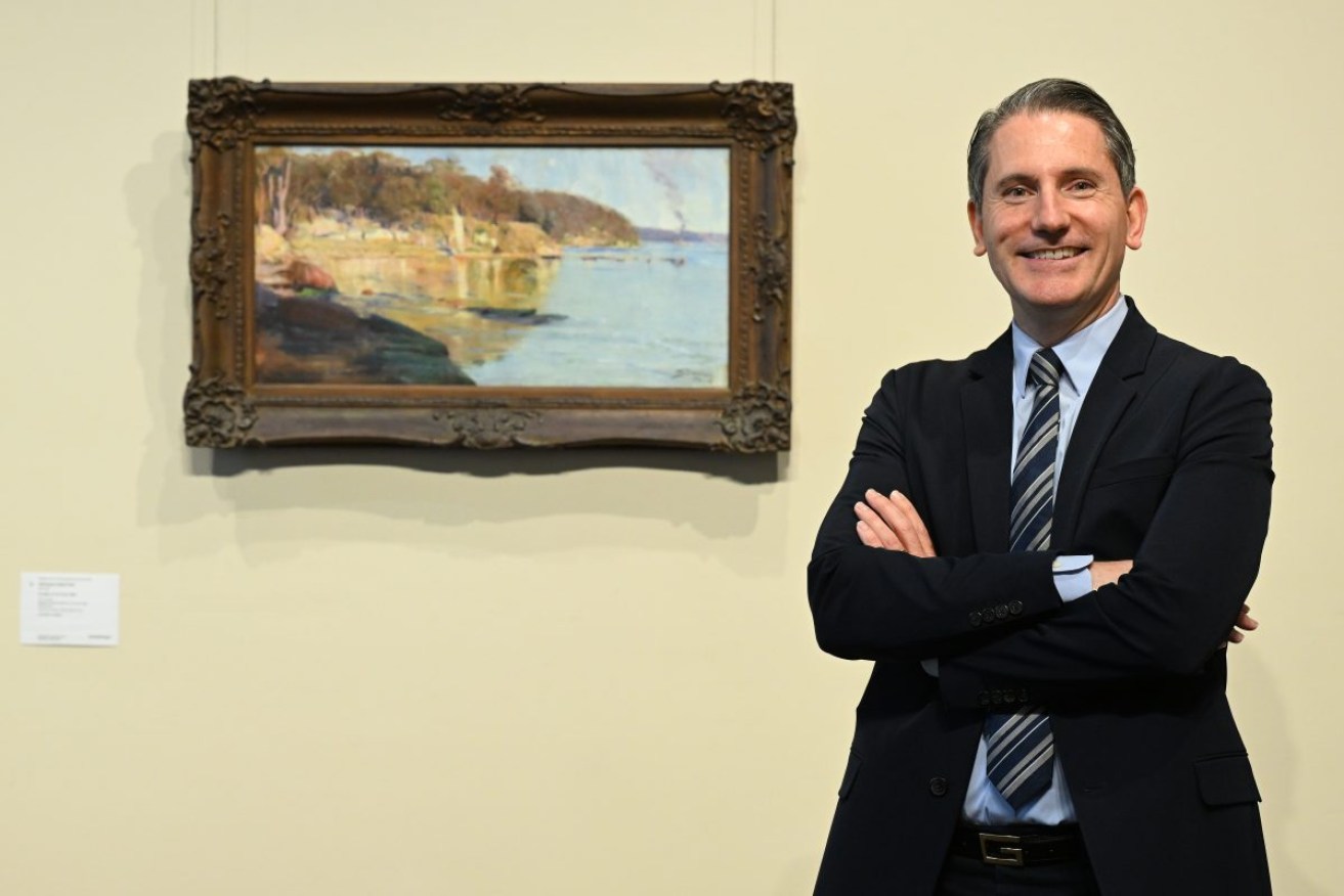 Geoffrey Smith, Chairman of Smith and Singer auction house poses for a photograph next to Arthur Streeton’s Sunlight at the Camp 1894 painting during a media call in Melbourne, Wednesday, April 3, 2024. The 1894 oil painting Sunlight at the Camp 1894 has gone on show in Melbourne ahead of auction in Sydney, where it's expected to fetch up to $1.5 million. (AAP Image/James Ross) NO ARCHIVING