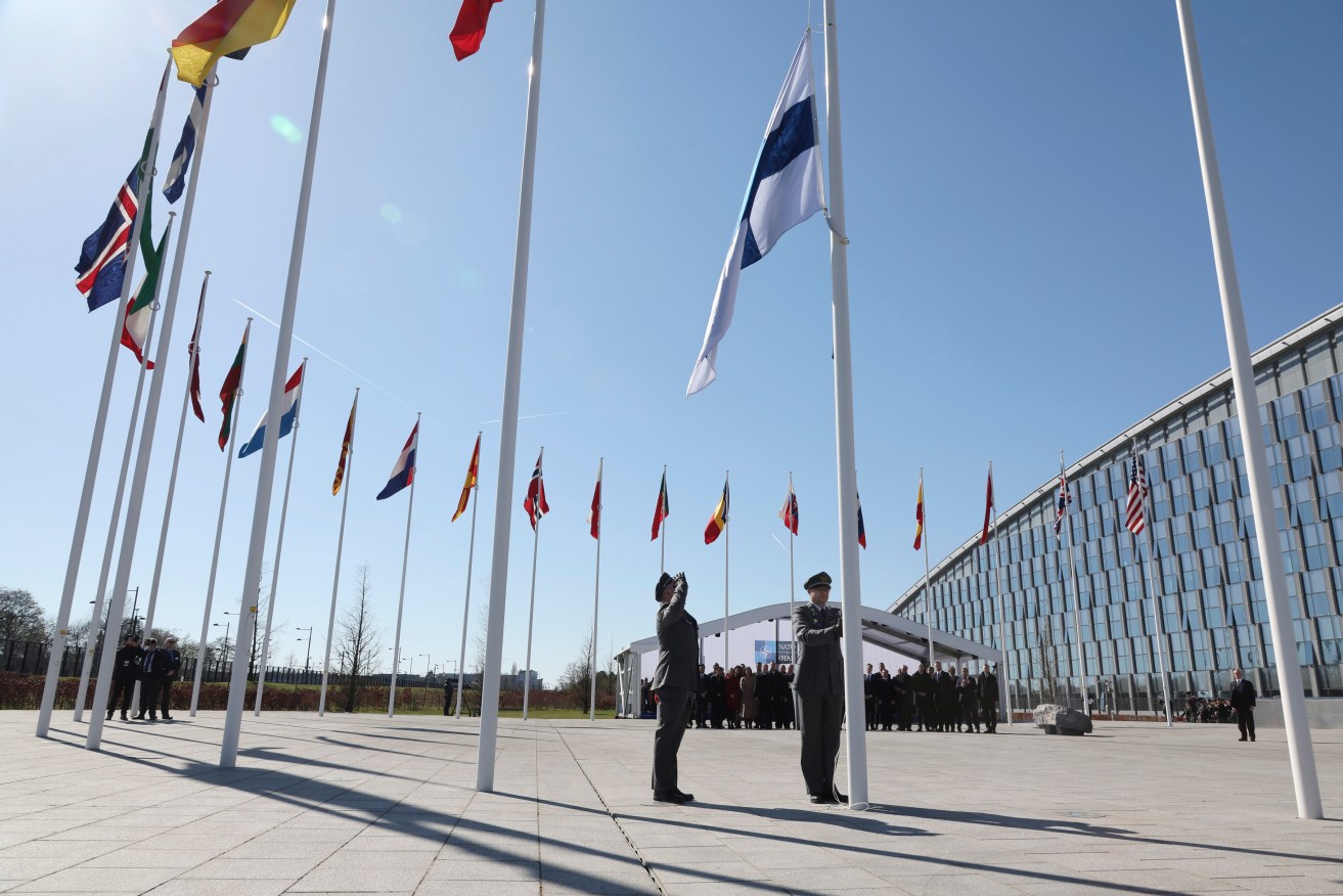 FILE - Military personnel raise the flag of Finland during a flag raising ceremony on the sidelines of a NATO foreign ministers meeting at NATO headquarters in Brussels, Tuesday, April 4, 2023. NATO is set to celebrate on Thursday, April 4, 2024, 75 years of collective defense across Europe and North America as Russia's war on Ukraine enters its third year. (AP Photo/Geert Vanden Wijngaert, File)