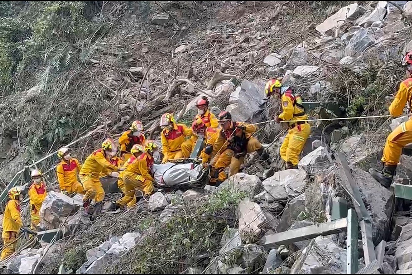 In this photo taken Thursday, April 4, 2024 and released by Pingtung Fire Department, firefighters evacuate a body from the Taroko National Park a day after a powerful earthquake struck, in the Hualien county, eastern Taiwan. Rescuers are searching for people out of contact a day after Taiwan's strongest earthquake in a quarter century damaged buildings, caused multiple rockslides. (Pingtung Fire Department via AP)