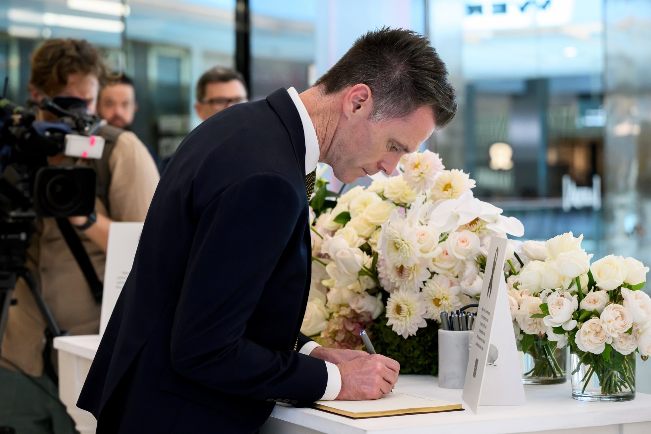 NSW Premier Chris Minns signs a condolence book whilst visiting a memorial to the victims who lost their lives in Saturday’s knife attack at Westfield Bondi Junction shopping centre, in Sydney, Thursday, April 18, 2024. Five women and one man were killed while 12 others were seriously wounded before a man was shot dead by police during a terrifying rampage at Westfield Bondi Junction on Saturday. (AAP Image/Bianca De Marchi) NO ARCHIVING
