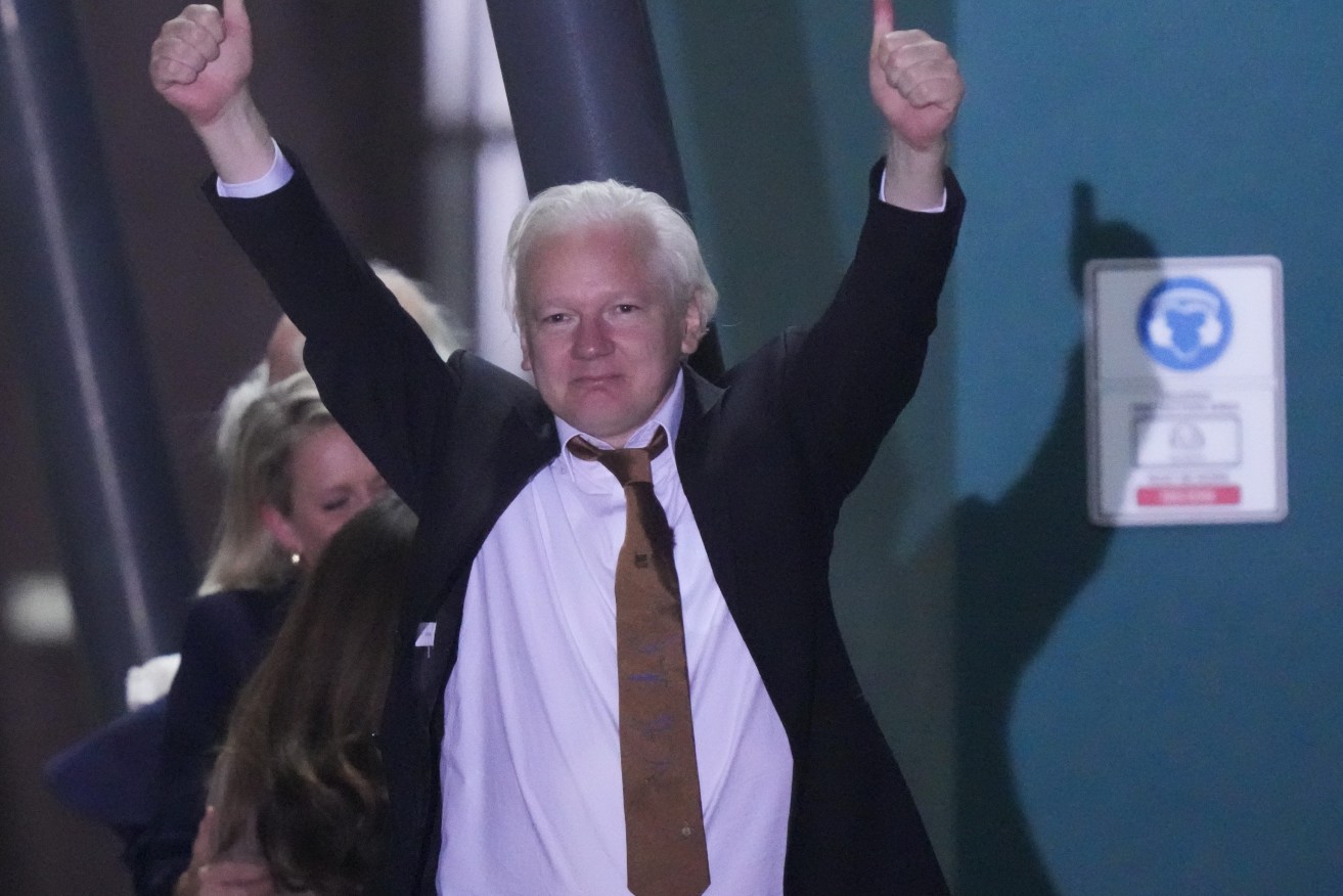 WikiLeaks founder Julian Assange gestures after landing at RAAF air base Fairbairn in Canberra, Wednesdaya.(AP Photo/Rick Rycroft)