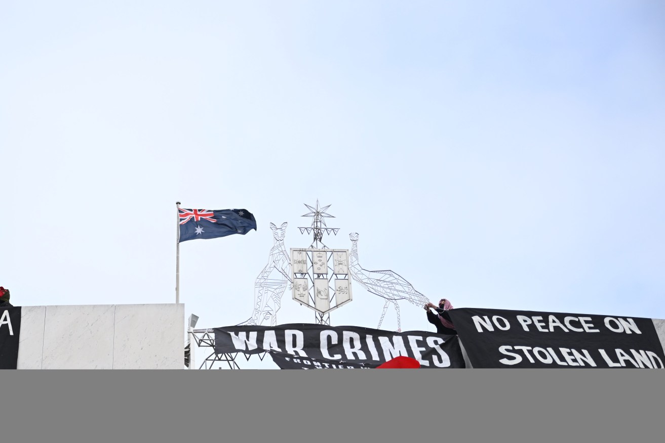 Pro-Palestine protesters hang banners from the top of Parliament House in Canberra, Thursday, July 4, 2024. (AAP Image/Lukas Coch) NO ARCHIVING